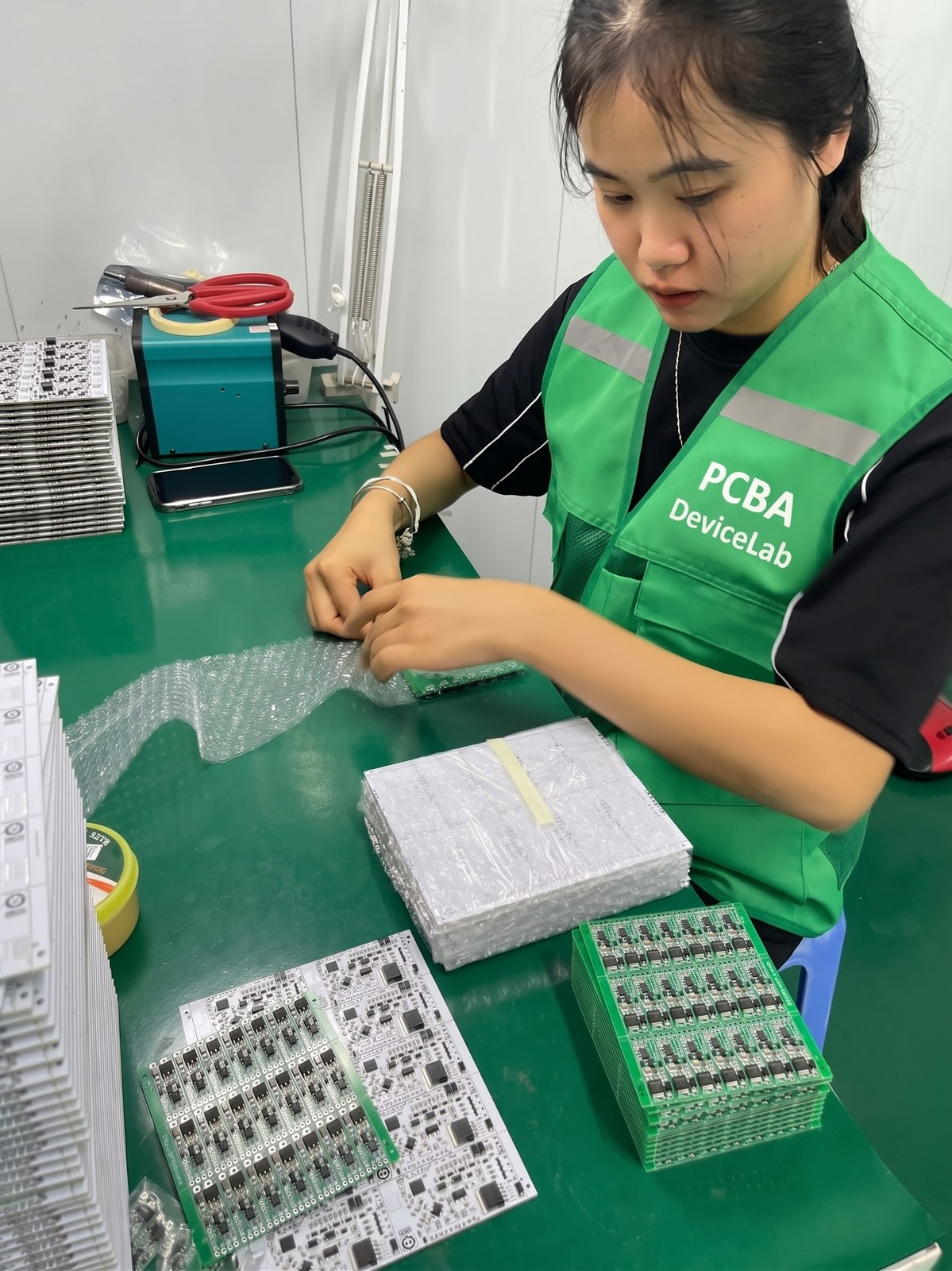 PCBA DeviceLab operator inspecting and packing PCB panels