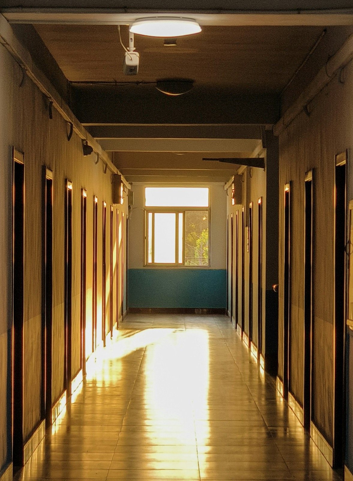 Modern school corridor with integrated ceiling speakers for zoned public address broadcasting