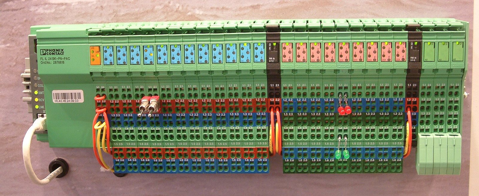 DIN rail terminal blocks inside industrial control cabinet showing sequential bus wiring
