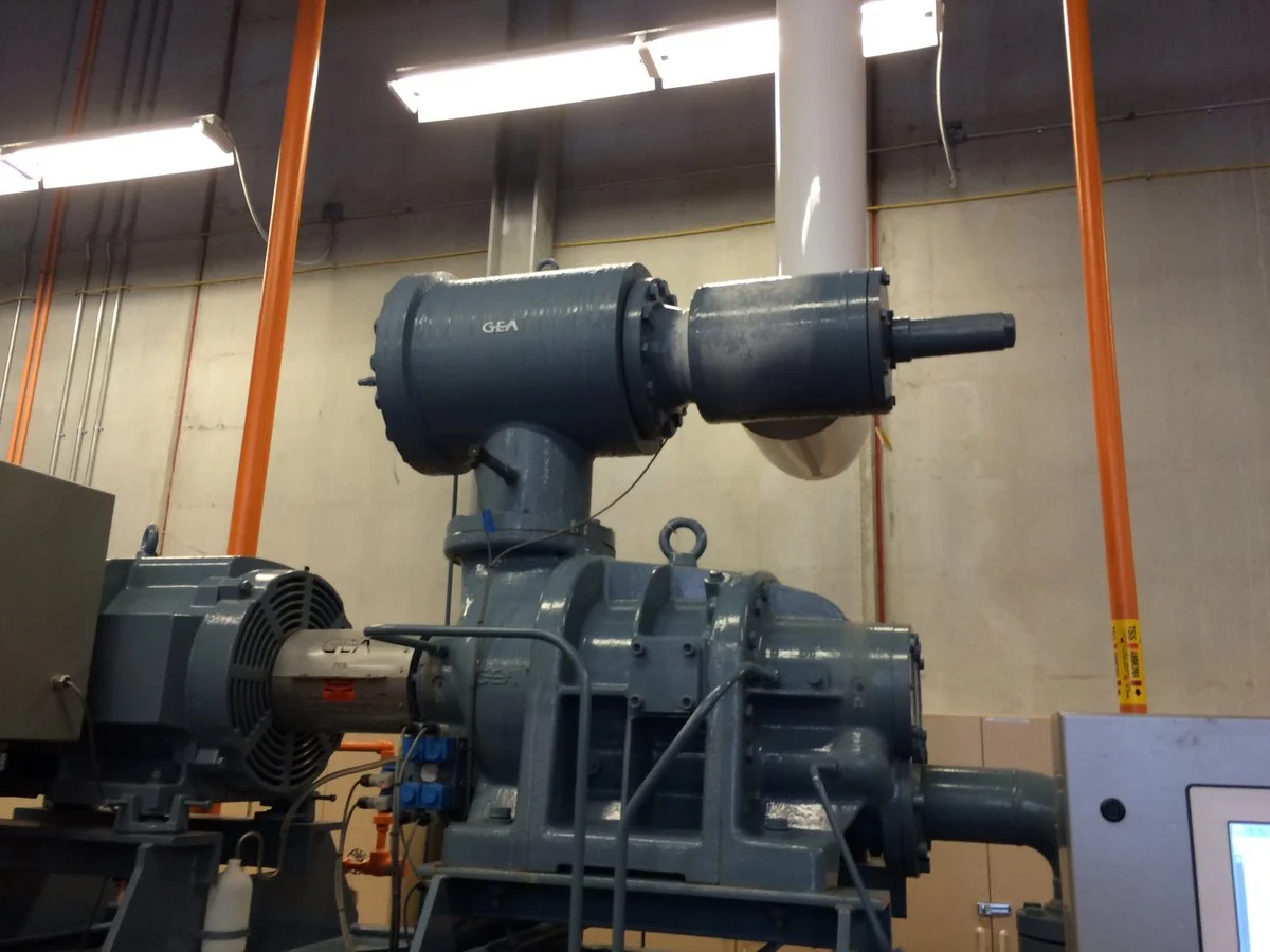 Internal view of rotary screw compressor airend, drive coupling, and main electric motor